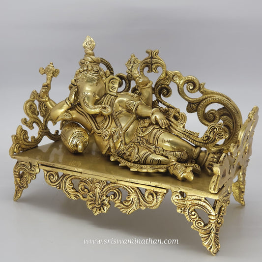 Decorative gold sculpture of a reclining figure on a gray background