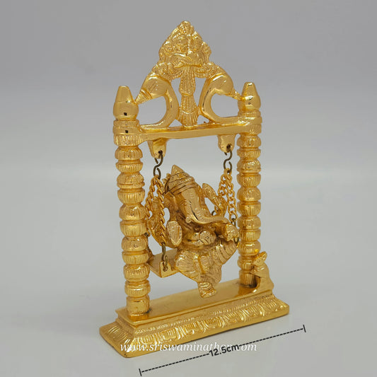 Gold-colored statue of a deity on a swing against a gray background