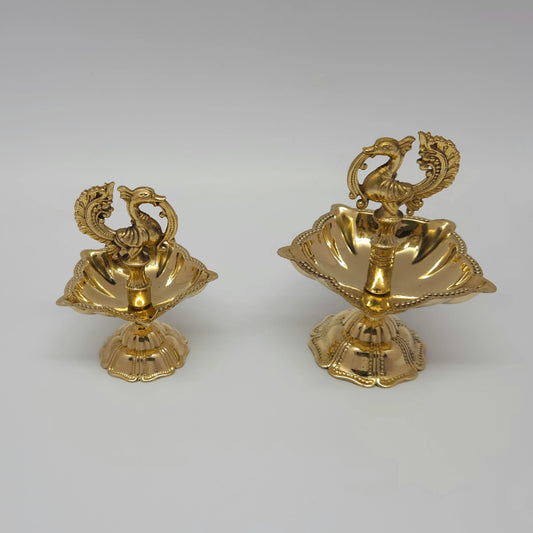 Top angle view showing two sizes of the brass peacock oil lamps.