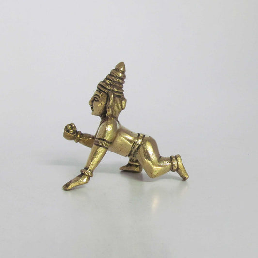 Side view of a solid brass crawling Laddu Gopal statue in an antique finish, highlighting the crawling posture and leg details.