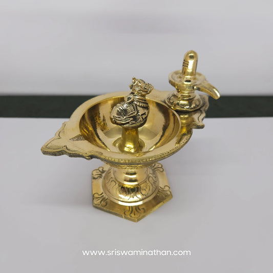 Side perspective view of a handcrafted pure brass Nandi Shiva Lingam stand diya, showing the elegant pedestal base and yoni profile.