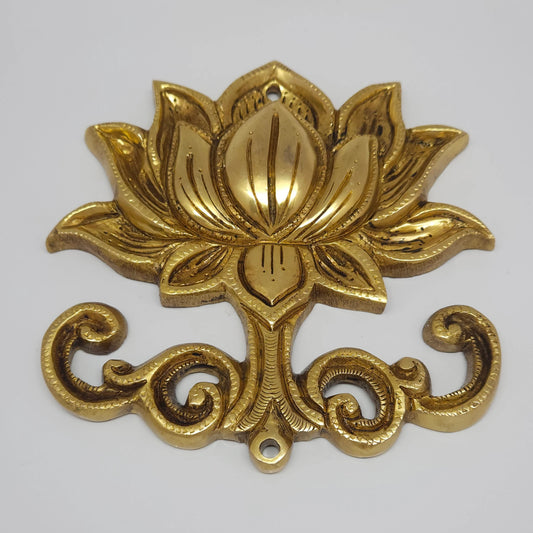 Three-quarter front perspective view of the brass lotus medallion wall decor highlighting the detailed chiseled petal layers and scrollwork base.