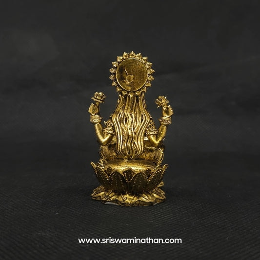 Direct straight back view of the solid brass Kubera Lakshmi statue demonstrating the detailed rear surface of the halo crown and lengthy hair curls over the base.