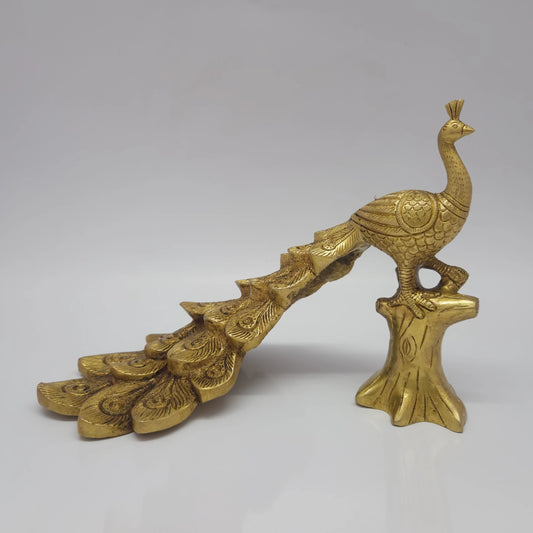 Low three-quarter front left profile view of the solid brass small peacock decor statue showcasing the detailed cascading lines of his long tail feathers.