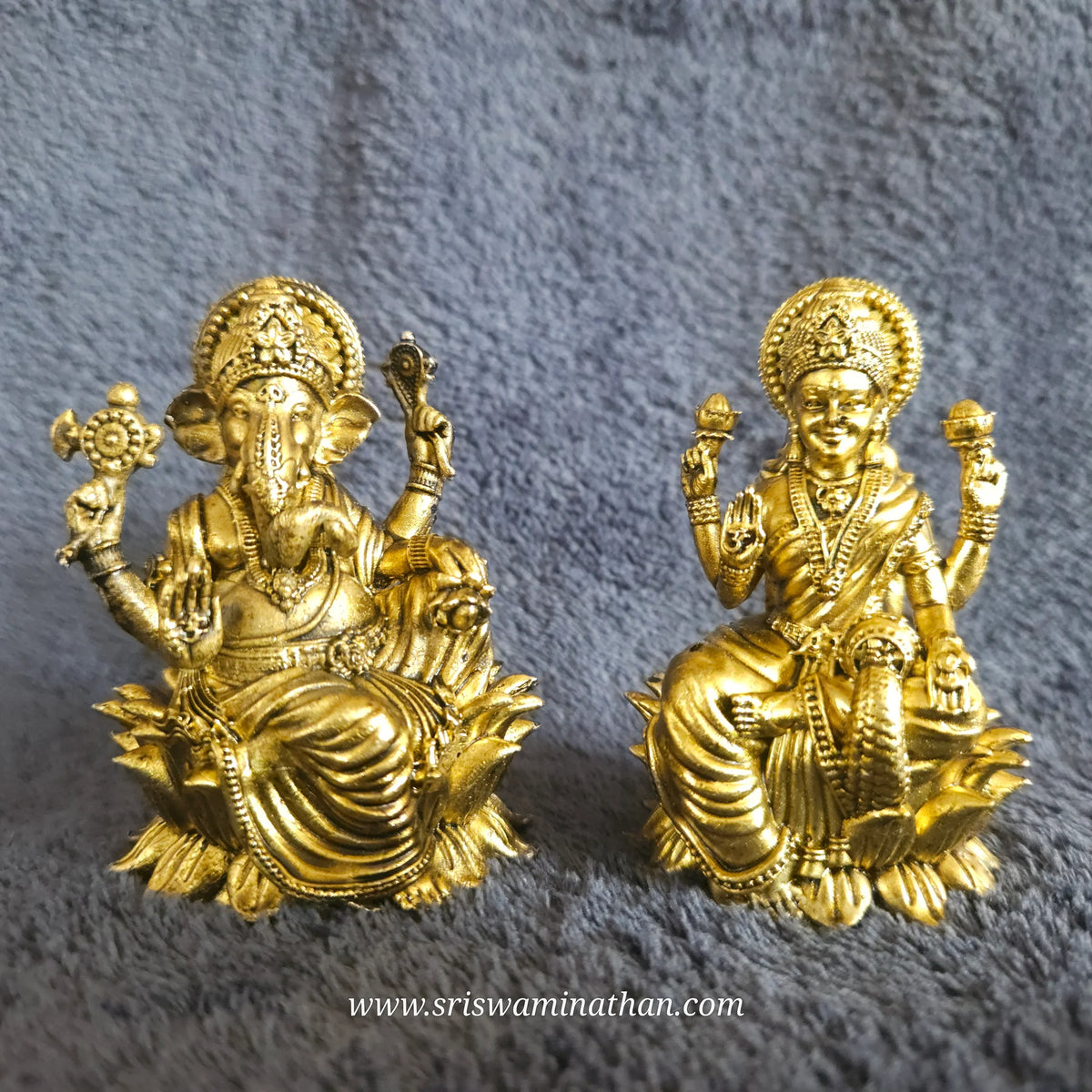 Front perspective view showcasing a paired set of the two point seven five inch brass seated Lalita Ganapati statue alongside a matching seated Lakshmi idol on an altar display