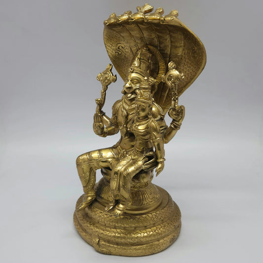 Left three-quarter angle view of the lacquer polished heavy brass Lakshmi Narasimha statue showcasing the fine details on the circular coiled snake throne.