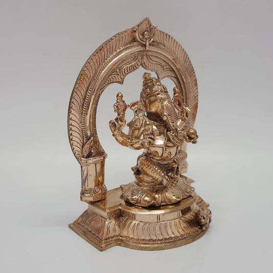 Three-quarter front perspective angle view of the five-metal Ganesha statue showing the physical thickness of the base pedestal and the side profile of the dynamic crown.