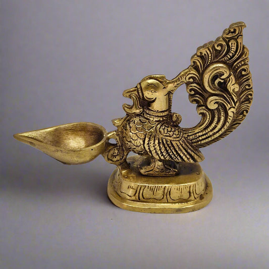 Decorative brass statue of a bird holding a lamp 