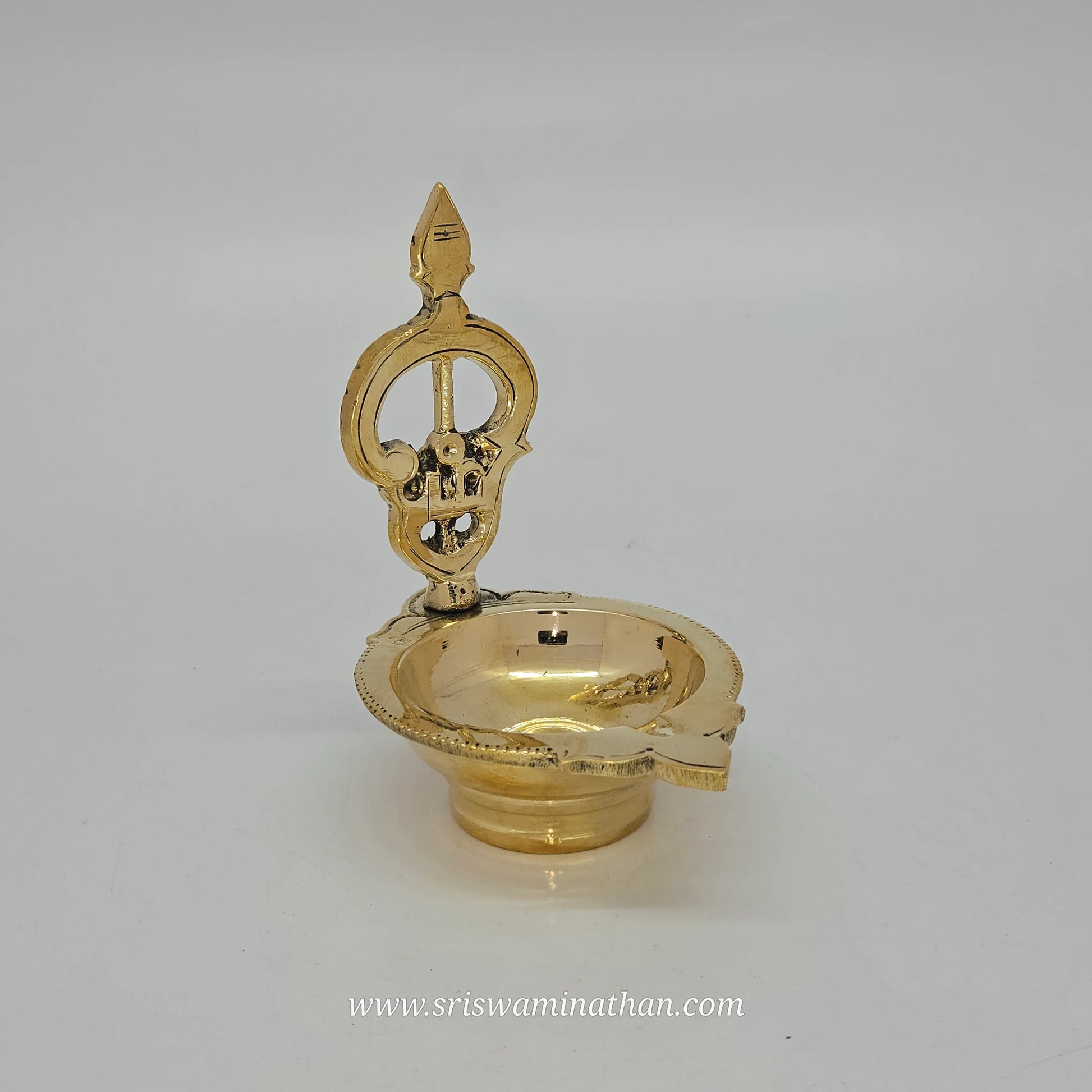Close-up view of Om Muruga Vel Vilakku showing intricate brass work and sacred spear details