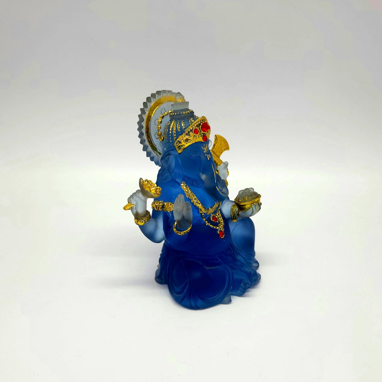 Beautiful turned view of the 6-inch frosted blue glass look Ganesha murti showing the light passing through the back.