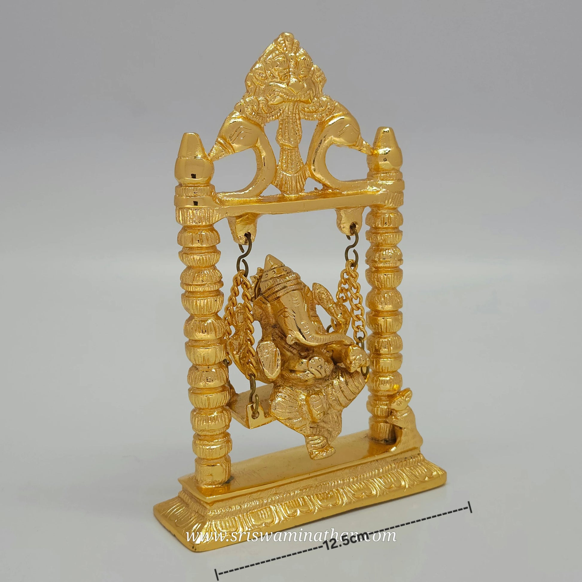 Gold-colored statue of a deity on a swing against a gray background