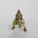 Direct front view of an antique finish brass crawling Bal Krishna idol, showcasing the facial features and traditional crown.
