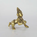 Three-quarter angle view of a solid brass crawling baby Krishna idol with a hand-rubbed antique patina finish, suitable for abishegam.