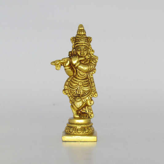 Direct front profile view of a pure brass fluting Krishna idol in tribhanga pose playing bansuri on a circular lotus base pedestal.
