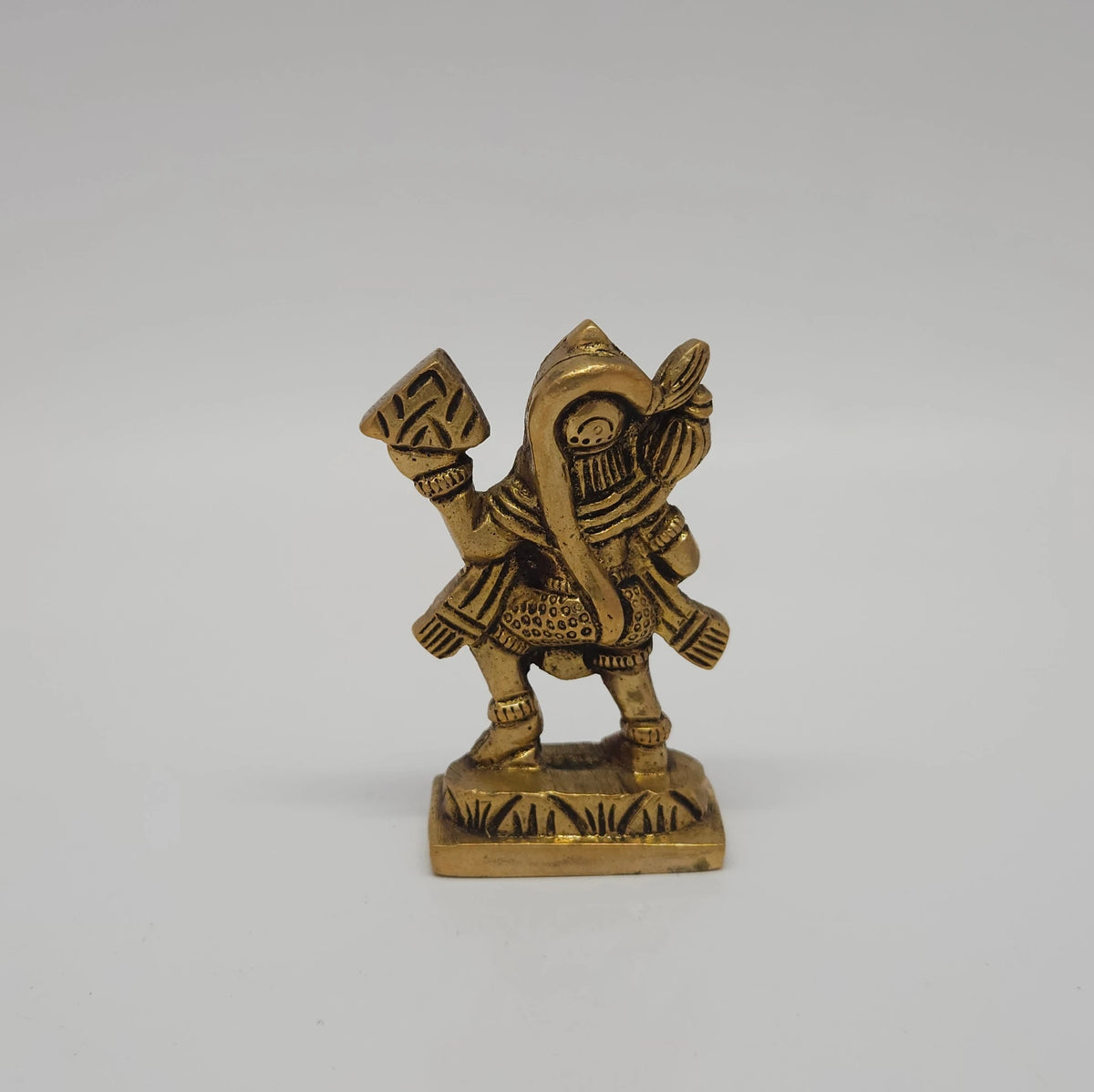Direct back profile view of the solid cast brass Sanjeevi Hanuman idol demonstrating the density of the metal casting, back sash details, and pedestal base alignment.
