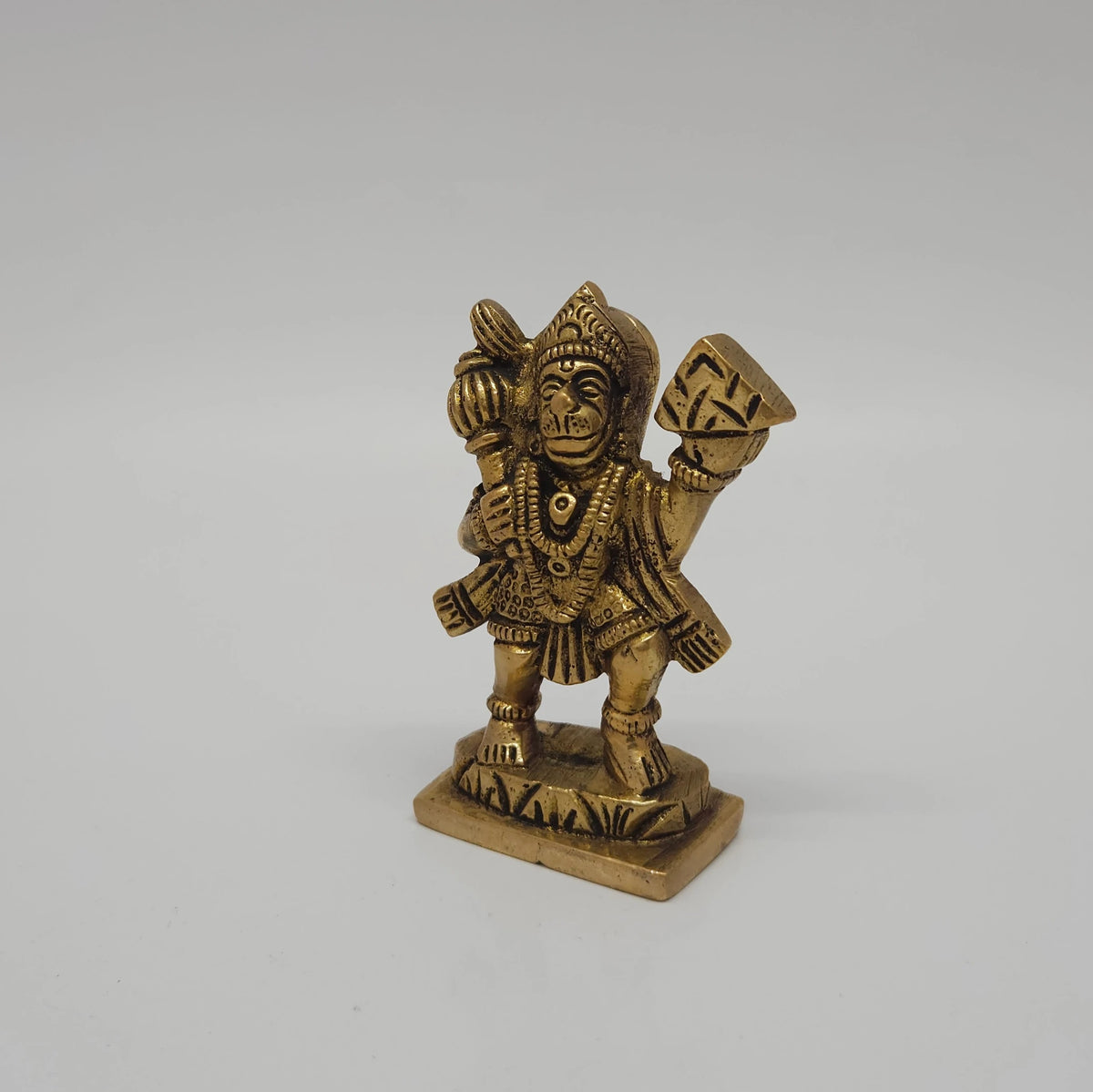 Three-quarter front left perspective view of the antique finish brass Sanjeevi Hanuman idol highlighting his courageous warrior stance and the crown details.