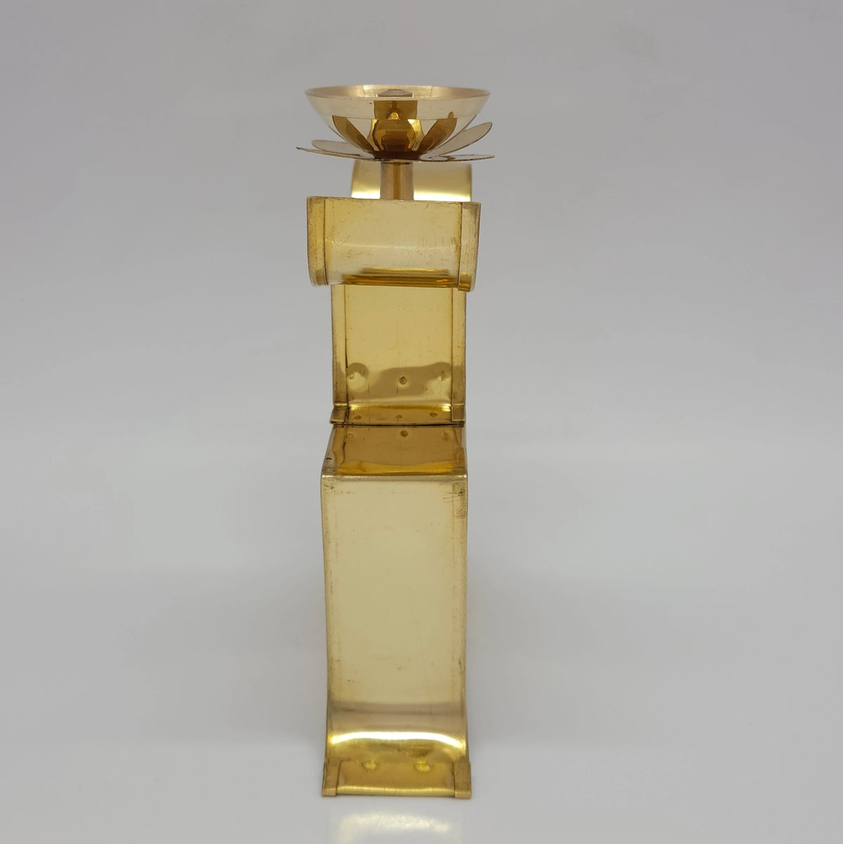 Back view profile of the 7 inch brass Swastik oil lamp standing upright on a flat surface.