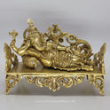Decorative gold statue of a reclining figure on a gray background