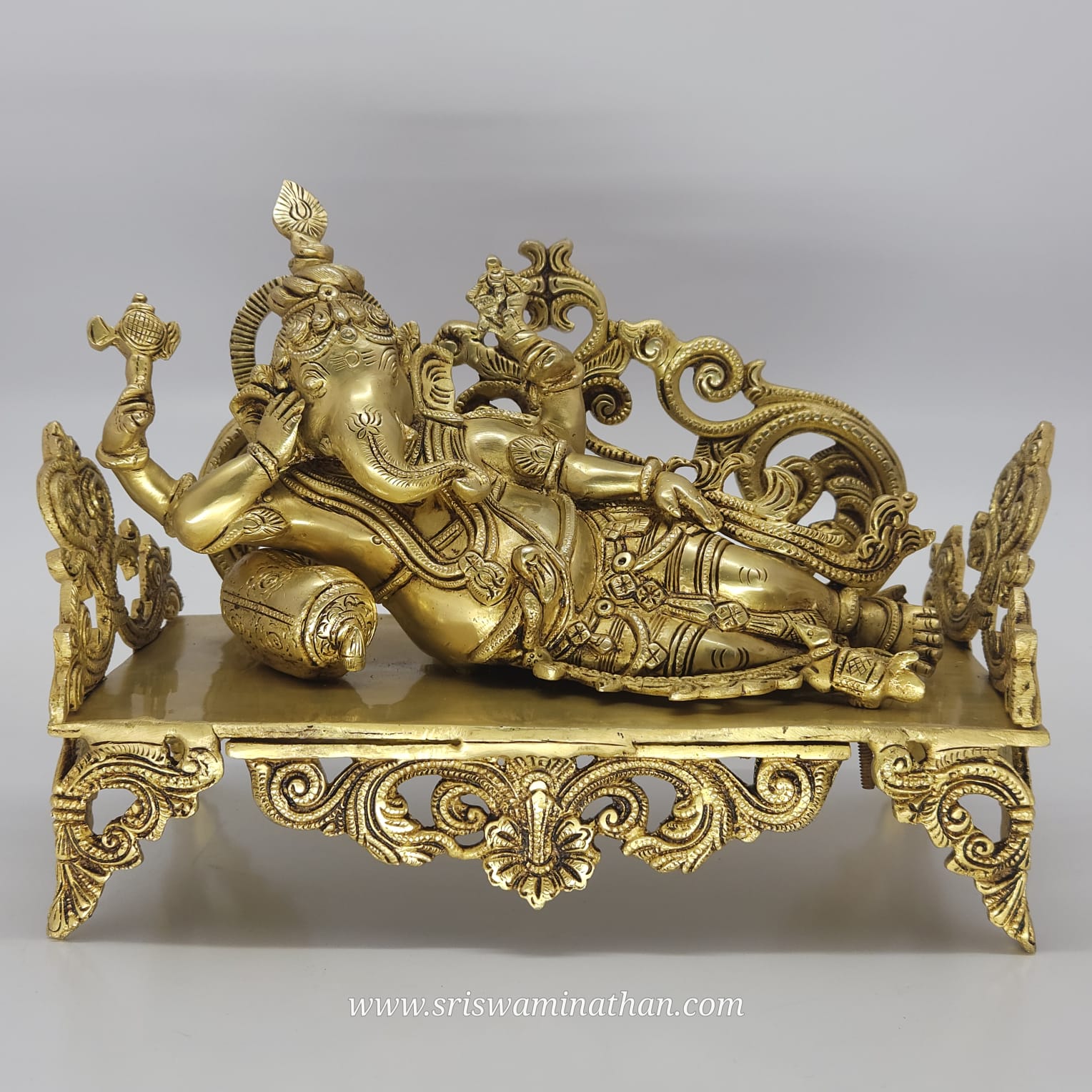 Decorative gold statue of a reclining figure on a gray background