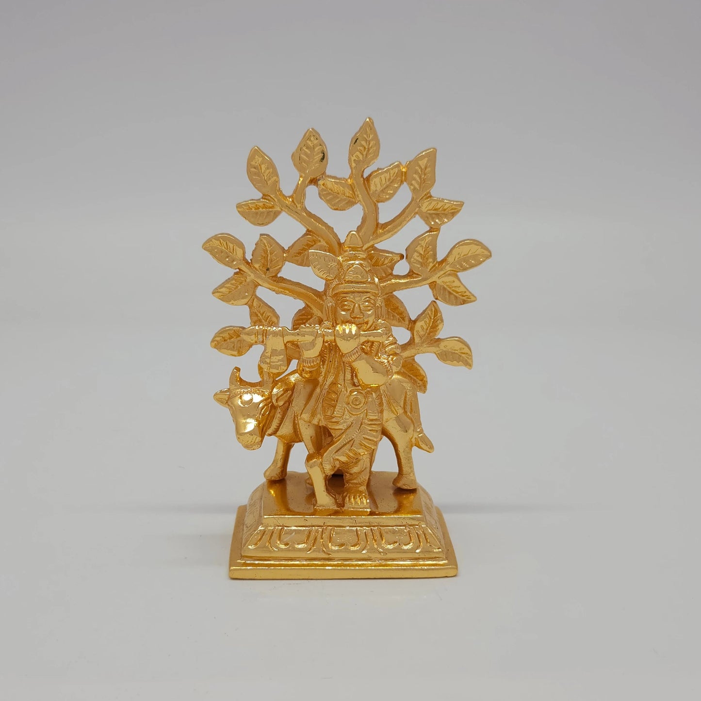 Front view of the 9.5cm premium gold powder-coated solid brass Krishna with cow under a Kadamba tree statue for Janmashtami gifting