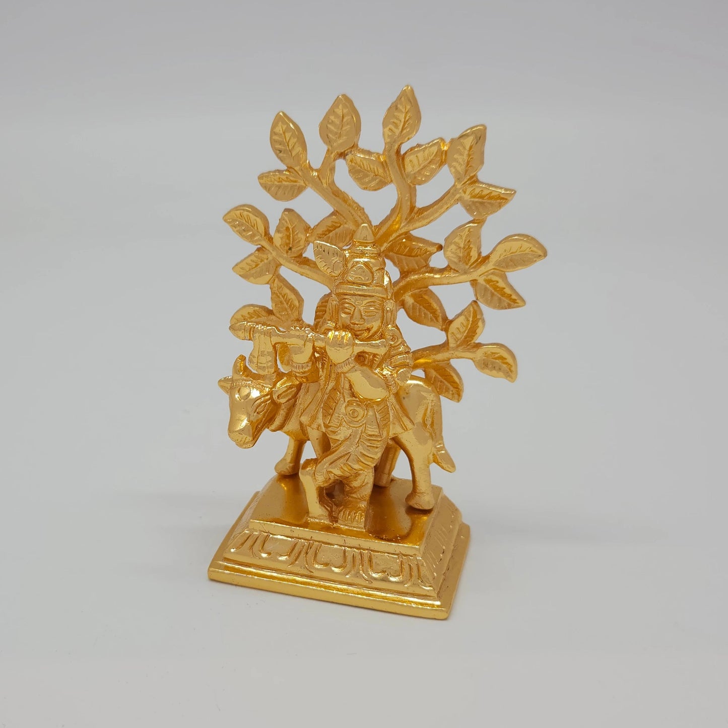 Left 45-degree angle profile emphasizing Krishna's cross-legged stance, the flute positioning, and the high-profile square base lines