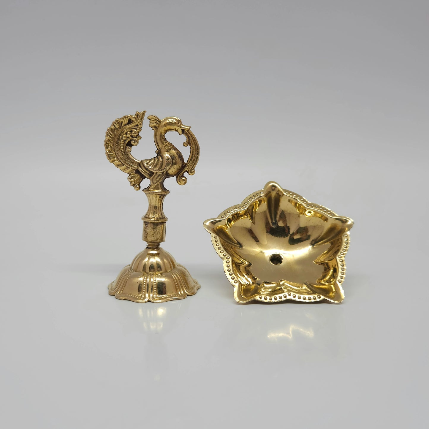 The brass peacock oil lamp unscrewed into two parts to show the travel-friendly design.