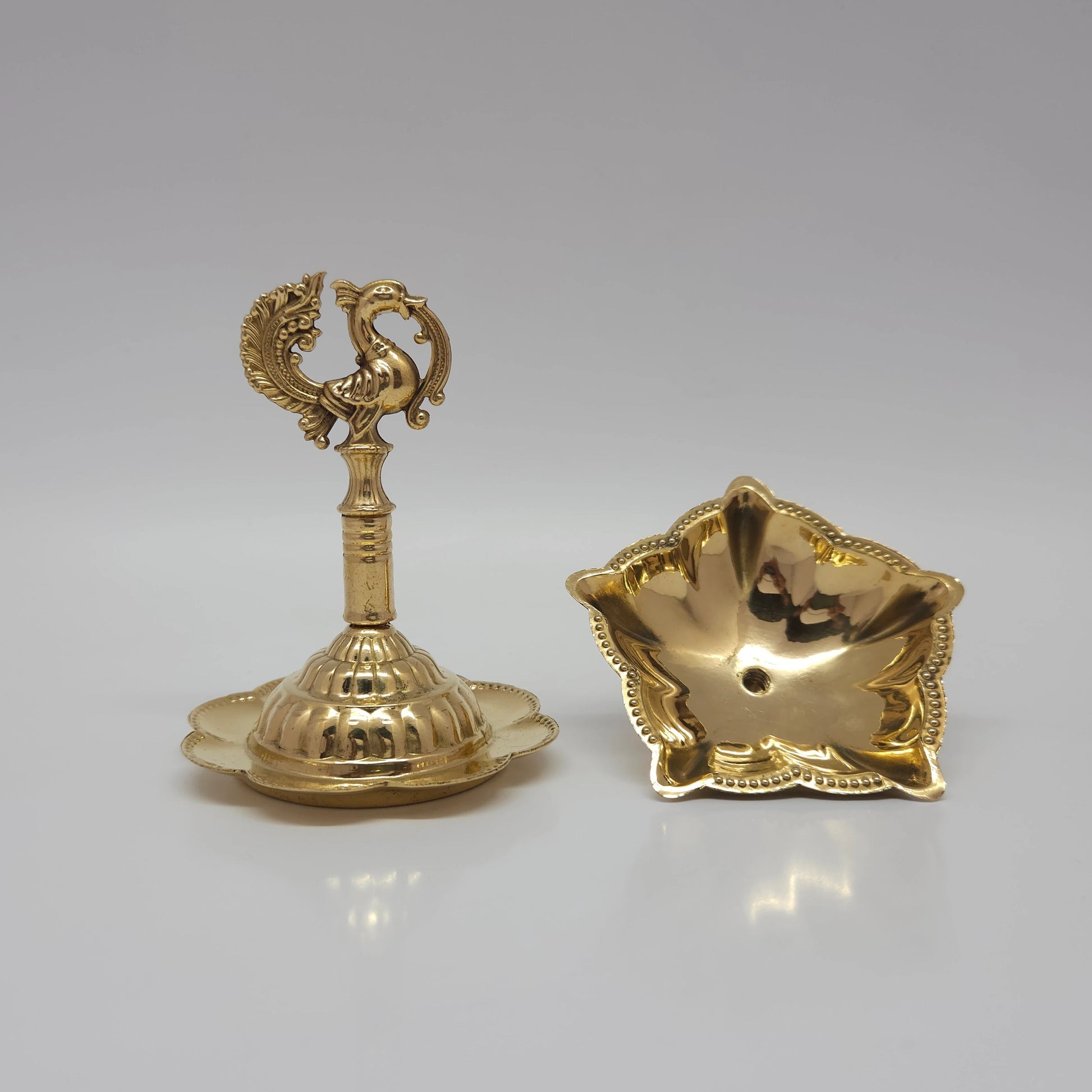 The brass peacock oil lamp unscrewed into two compact parts for travel or cleaning.