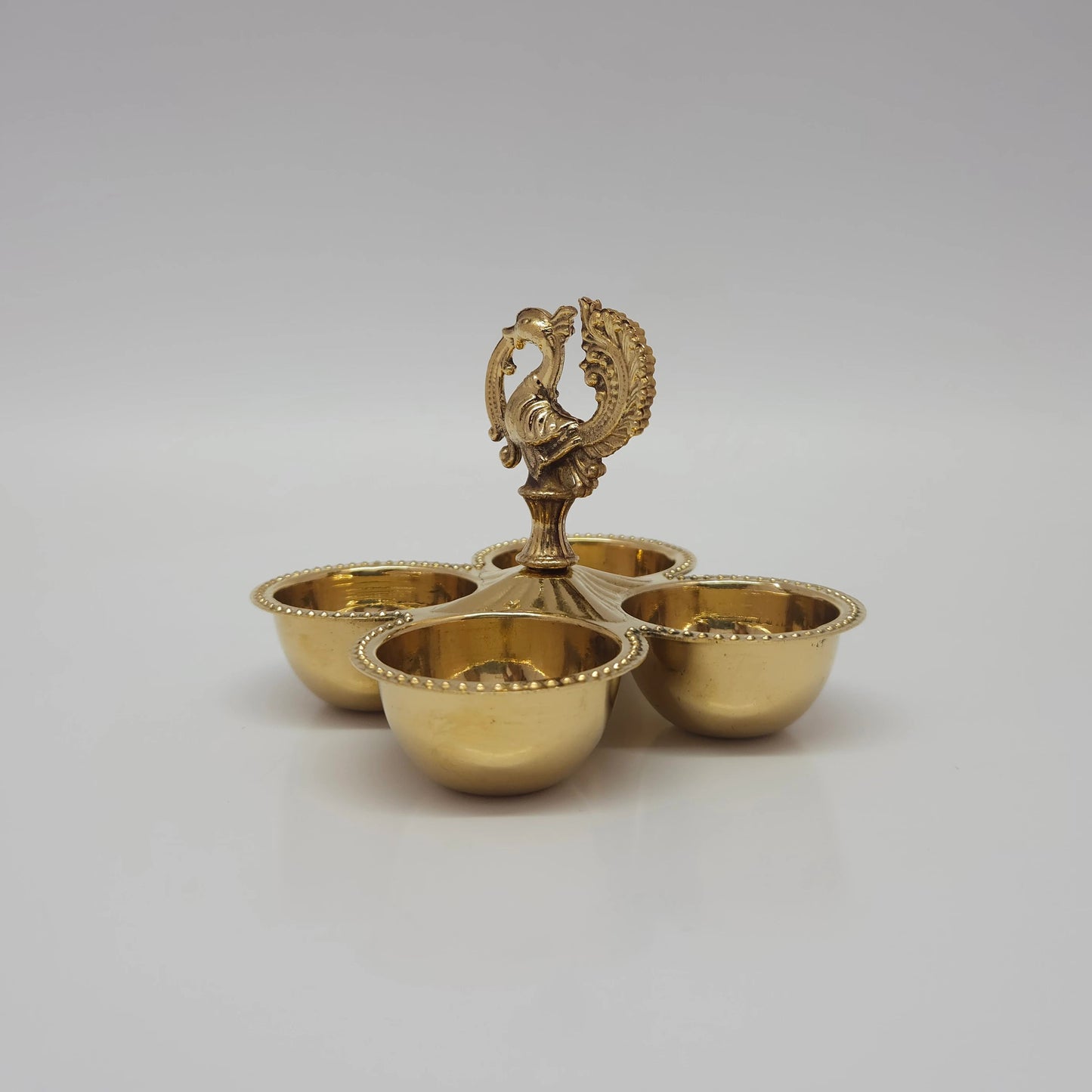 Side angle look at the four-cup brass peacock stand that can also be used as a multi-wick oil lamp.