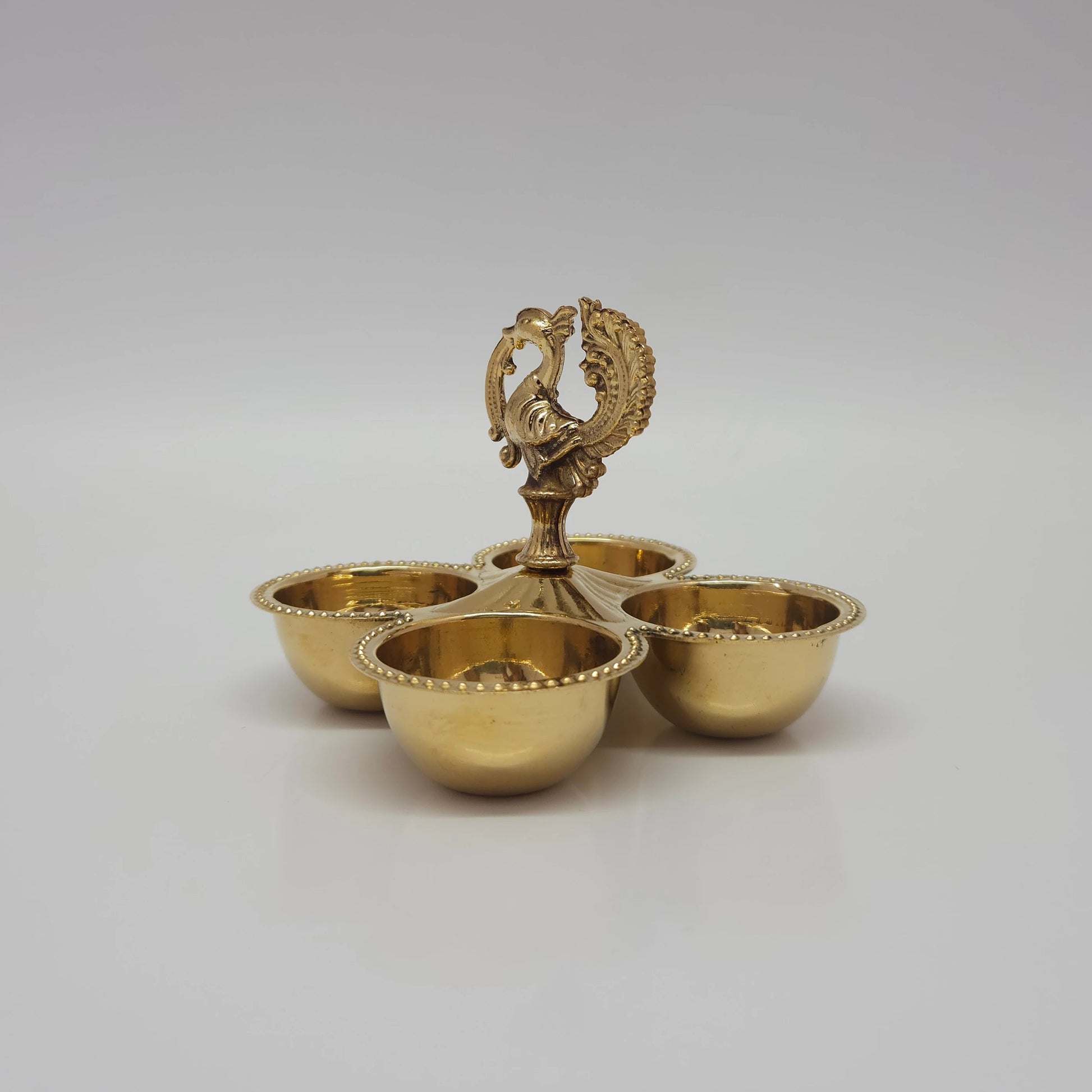 Side angle look at the four-cup brass peacock stand that can also be used as a multi-wick oil lamp.