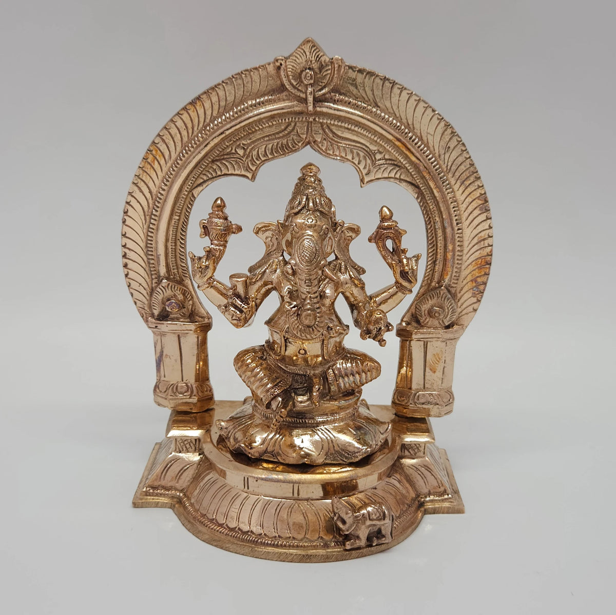Front straight profile view of the 6.3 inch authentic Swamimalai Panchaloha seated Ganesha statue showing the detailed removable Prabhavali arch, lotus pedestal, and Mooshika mouse base from Sri Swaminathan and Co stock