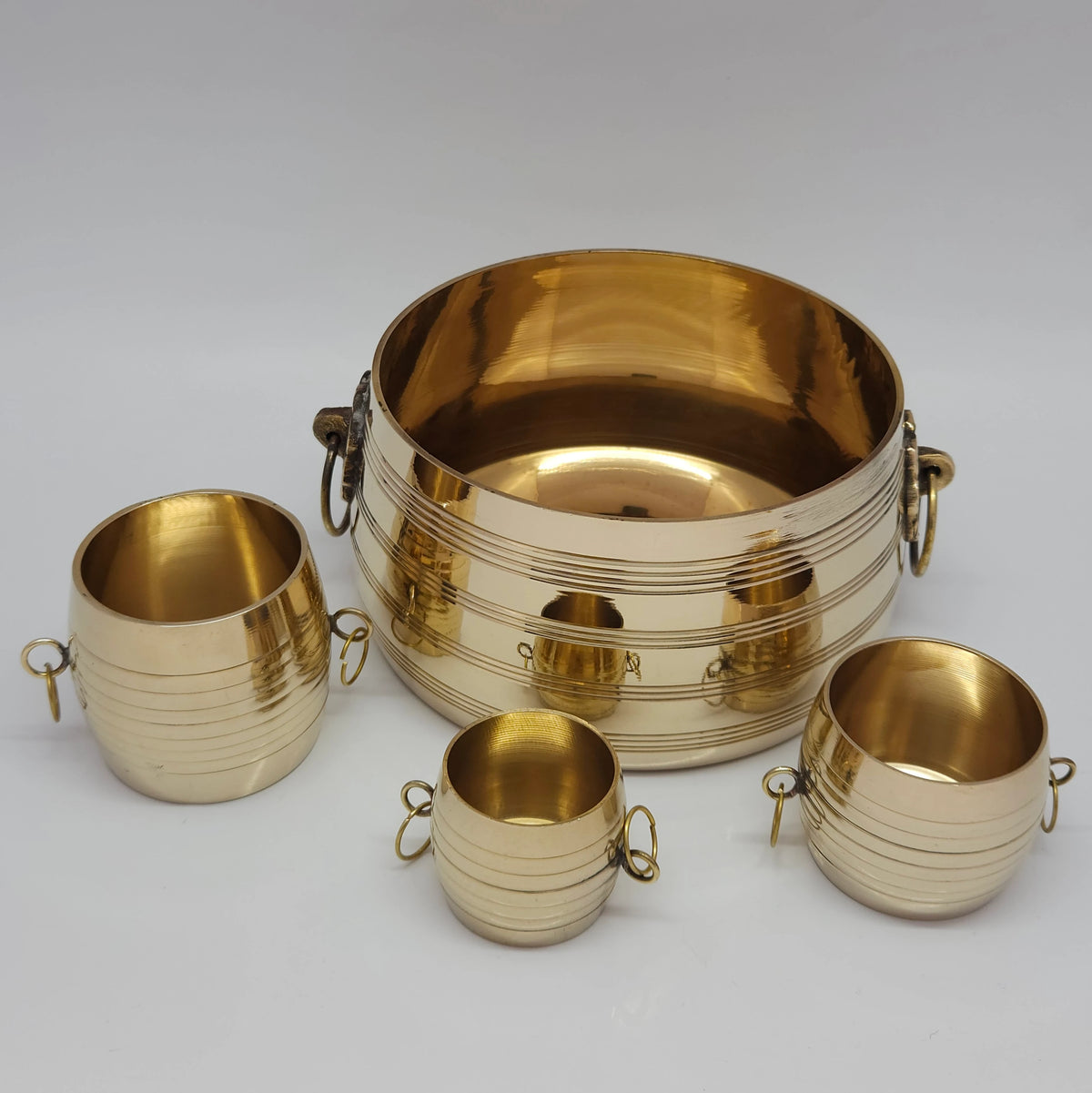 Slight high-angle view of the full pure brass chiri kinnam set highlighting the polished golden interiors of the four nested containers.
