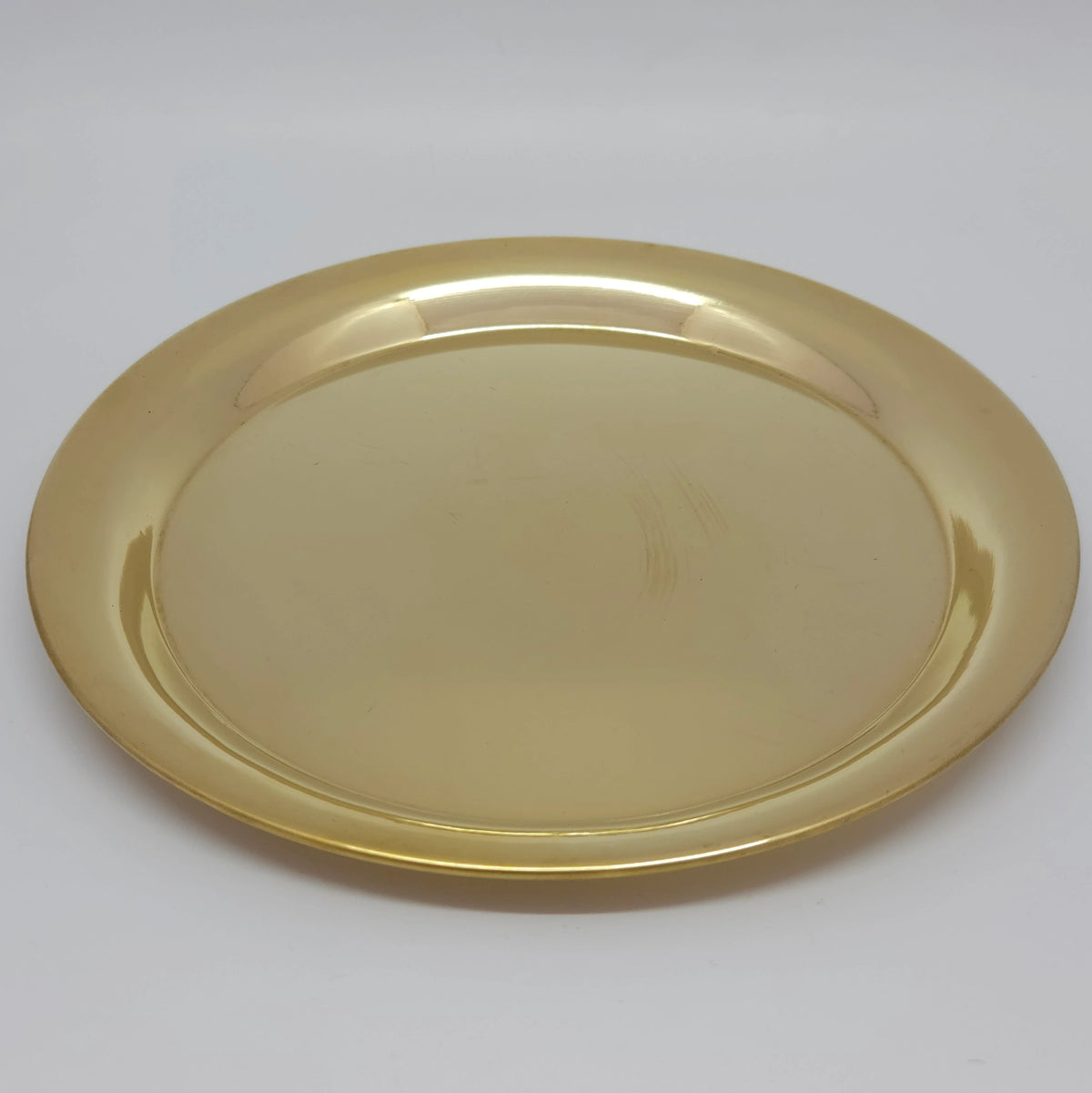 Overhead perspective view of the brass plain plate laid flat on a clean surface highlighting the continuous glossy sheen.