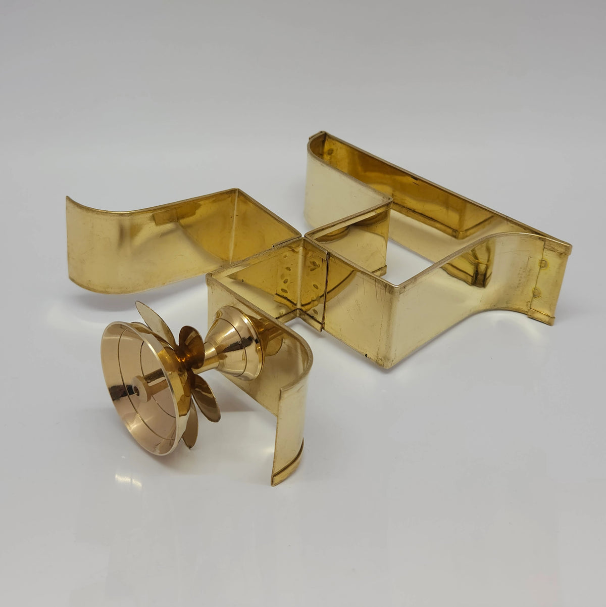 Top down view of the brass Swastik diya structure showing the secure weld of the oil cup holder and clean metal edges.
