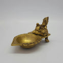 Front-left 45-degree angle profile view highlighting Kubera's sleeping pose stance on the pedestal with one leg visible and the lamp basin layout.