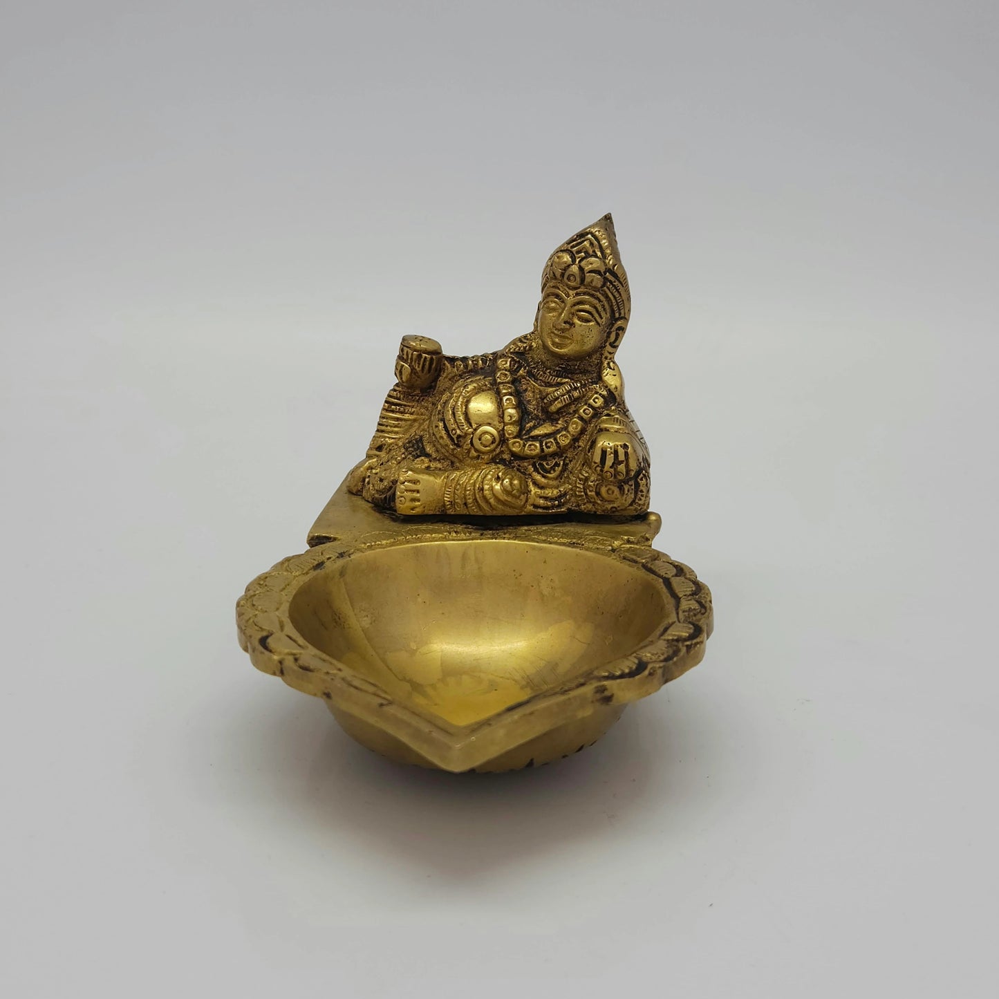 Flat straight front view of the 9.5cm high antique solid brass Kubera Deepam statue showing the deep oil reservoir container