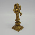 Solo right 45-degree angle close-up of the antique solid brass Goddess Lakshmi idol focusing on the hand-rubbed temple shading along the saree folds and tiered base.