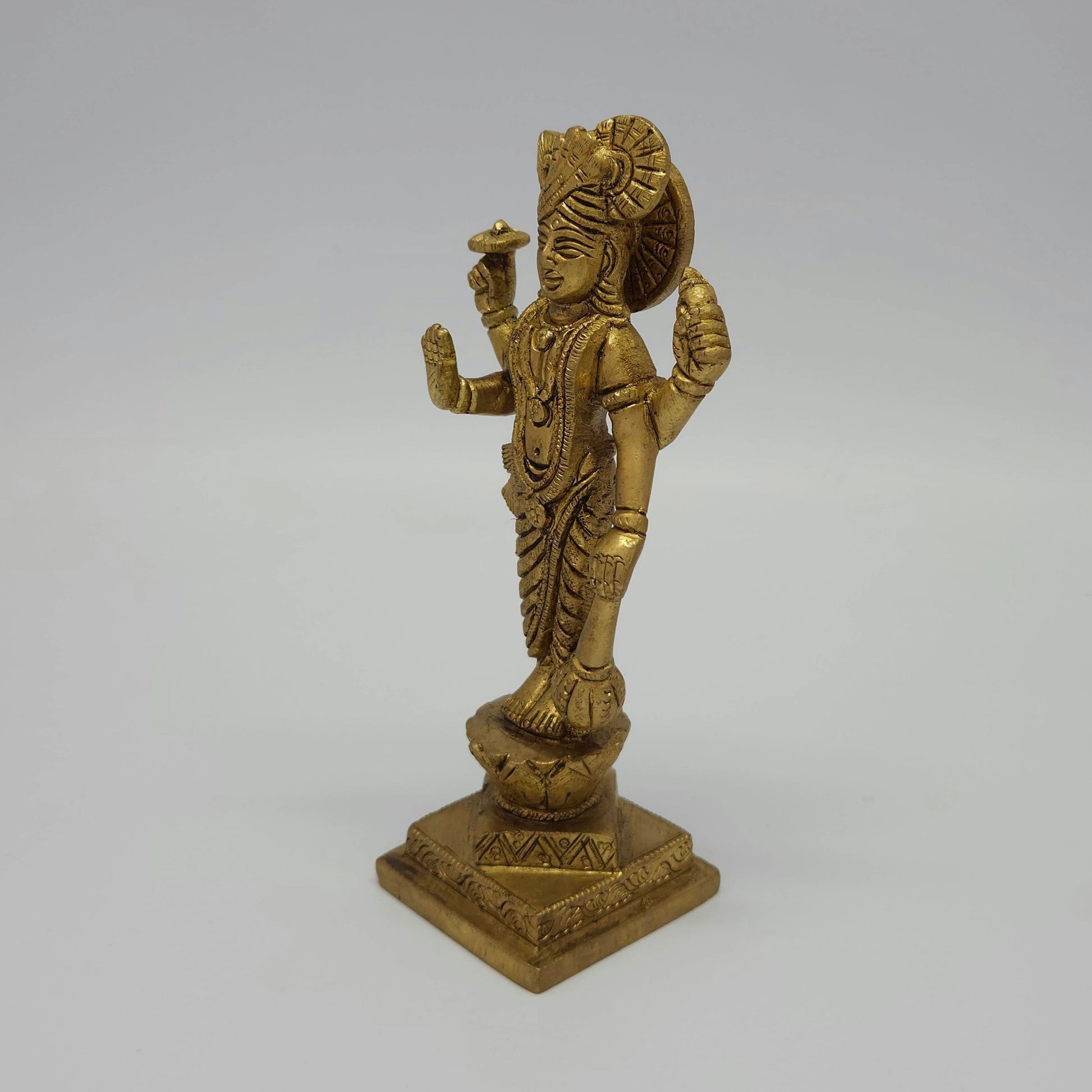 Solo left 45-degree angle profile view of the 17cm antique solid brass Lord Narayana statue highlighting the chiseled Sudarshana Chakra weapon and side drapery