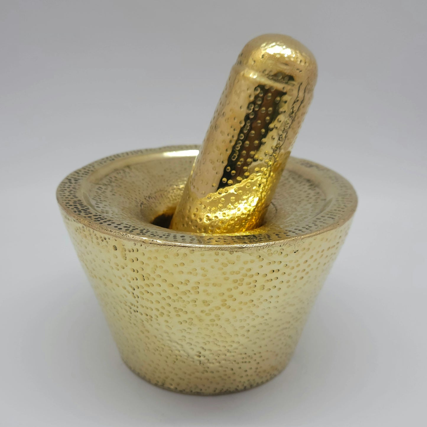Left 45-degree angle high perspective highlighting the hand-hammered dimple texture and polished golden finish of the Rubbu Rolu set.
