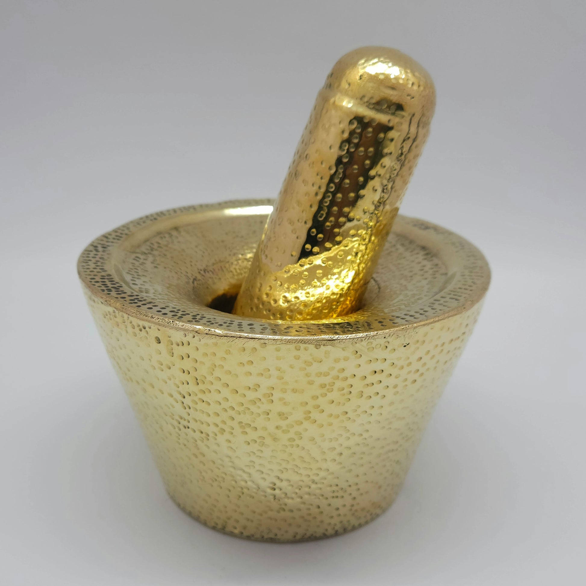 Left 45-degree angle high perspective highlighting the hand-hammered dimple texture and polished golden finish of the Rubbu Rolu set.