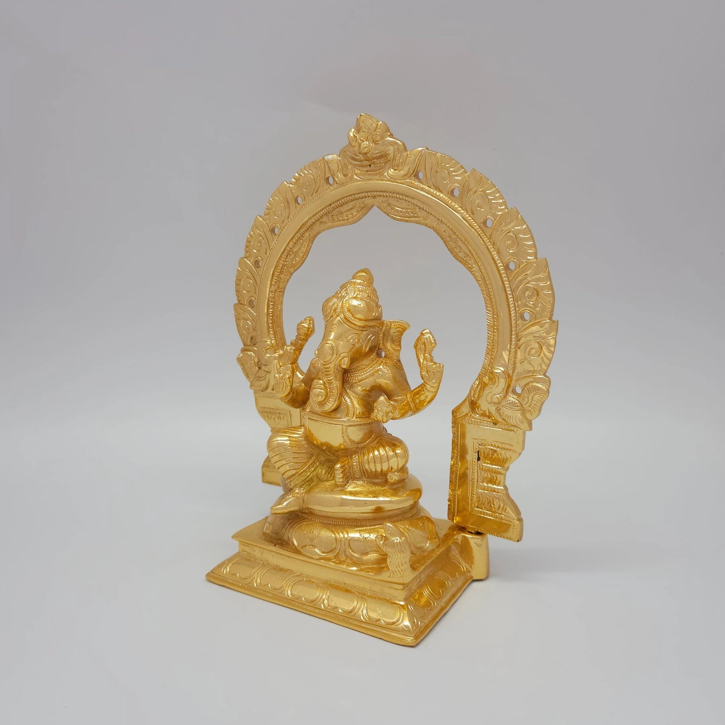 Left 45-degree angle profile emphasizing Ganesha's weapon details, the archway side pillars, and the square base steps