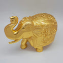 Left 45-degree angle high aerial view focusing on the curved trunk holding a wealth ball, large outstretched gigantic tusks, and detailed creased ear lines.