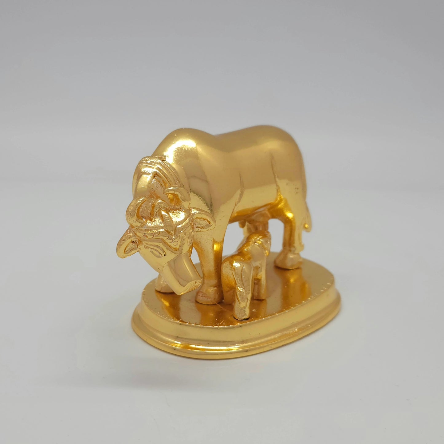Front-right 45-degree angle profile view focusing on the serene cow facial lines, horns, and the clean circular pedestal rim