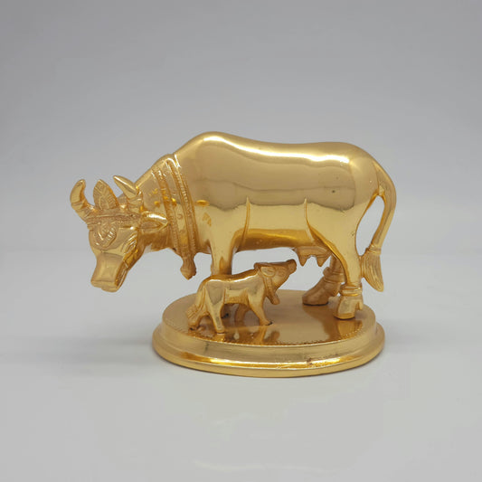 Flat straight front view of the premium high-gloss satin gold brass Kamadhenu cow and calf statue showing the ornate crown carvings