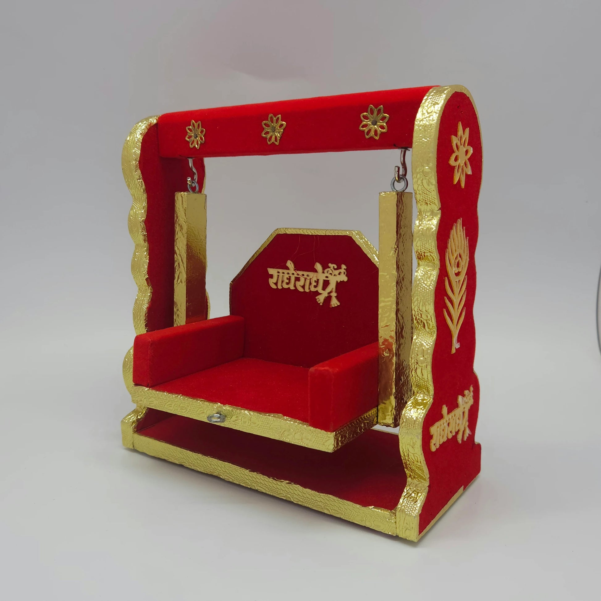 Front 45-degree angle view of the 21cm premium crimson red velvet wooden Laddu Gopal jhula swing set with golden Radhe Radhe embossed details.