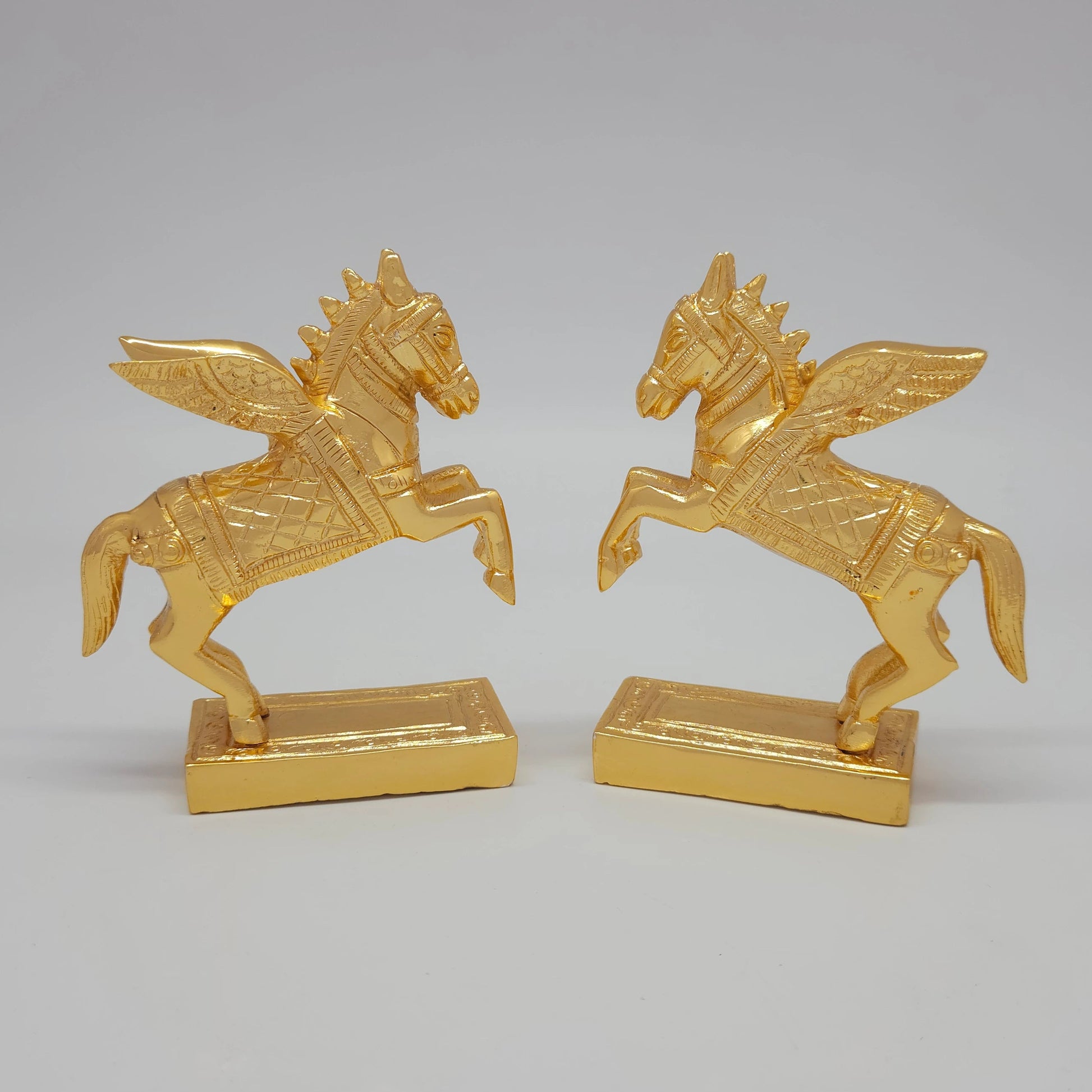 Front angle perspective showing a paired mirror display of the decorative gold finish solid brass winged horse figurines