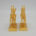 close-up emphasizing the rearing front hooves and the thick solid block base layout of the paired metal ornaments.