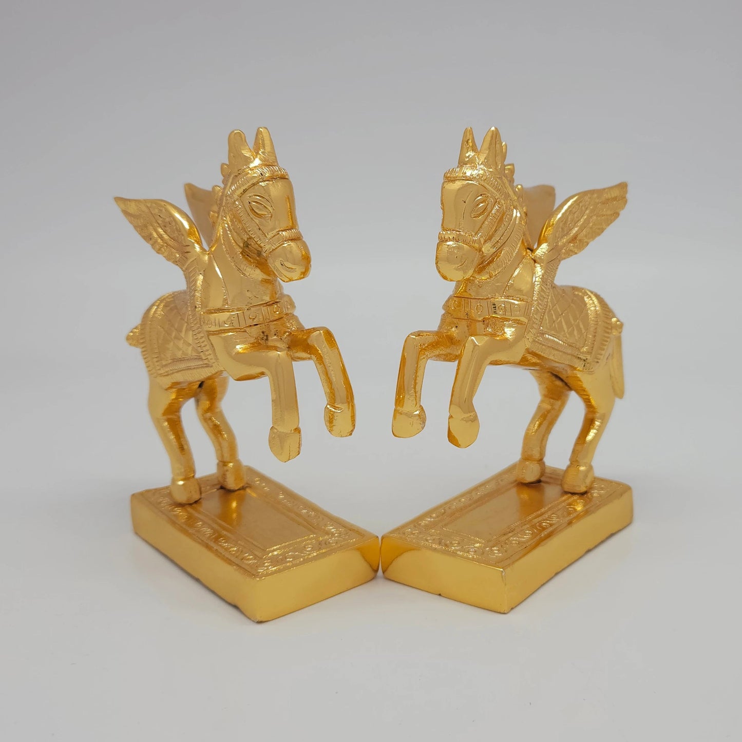45-degree angle profile showcasing the diamond-weave saddle pattern and intense mirror-gold luster lines on the paired horse figures