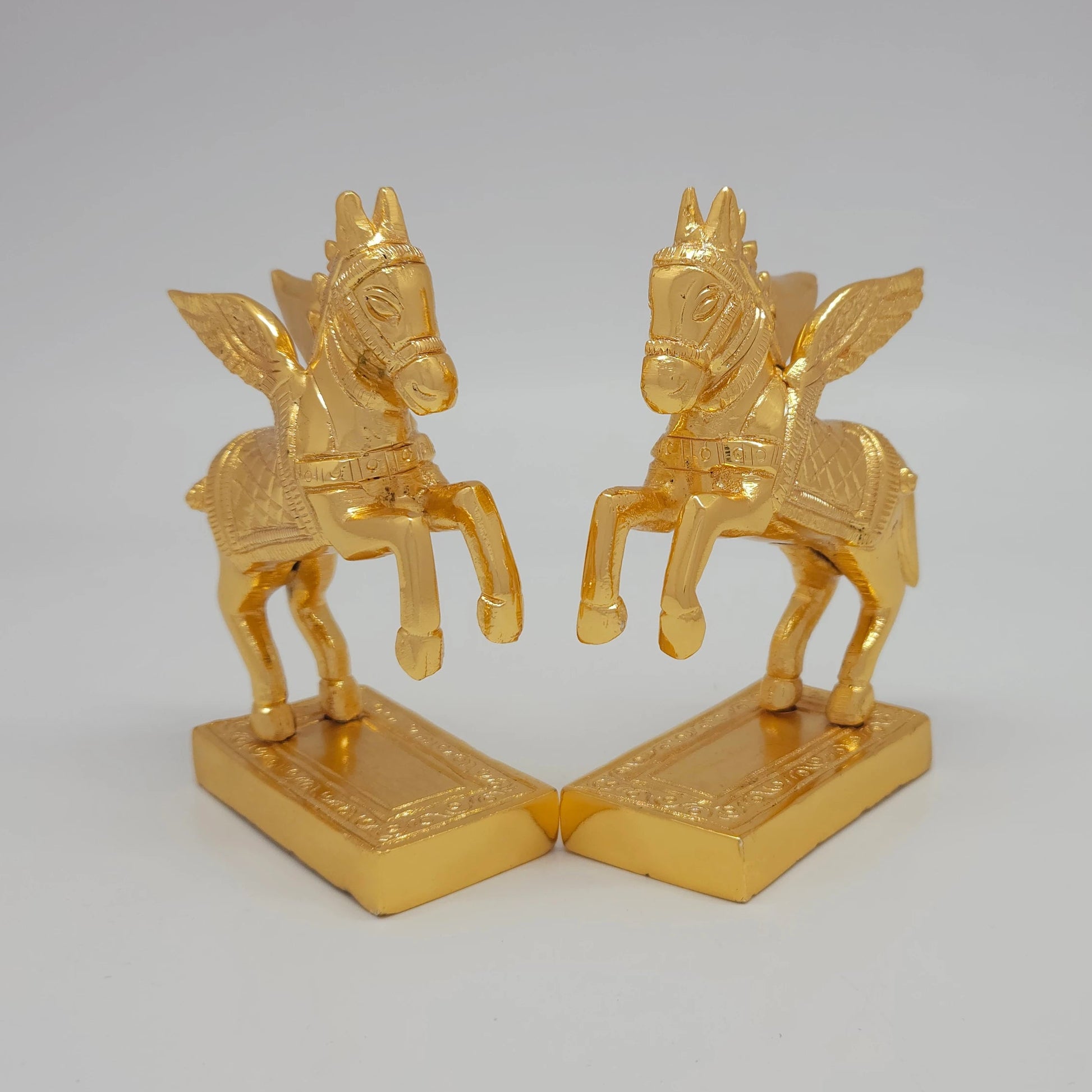 45-degree angle profile showcasing the diamond-weave saddle pattern and intense mirror-gold luster lines on the paired horse figures