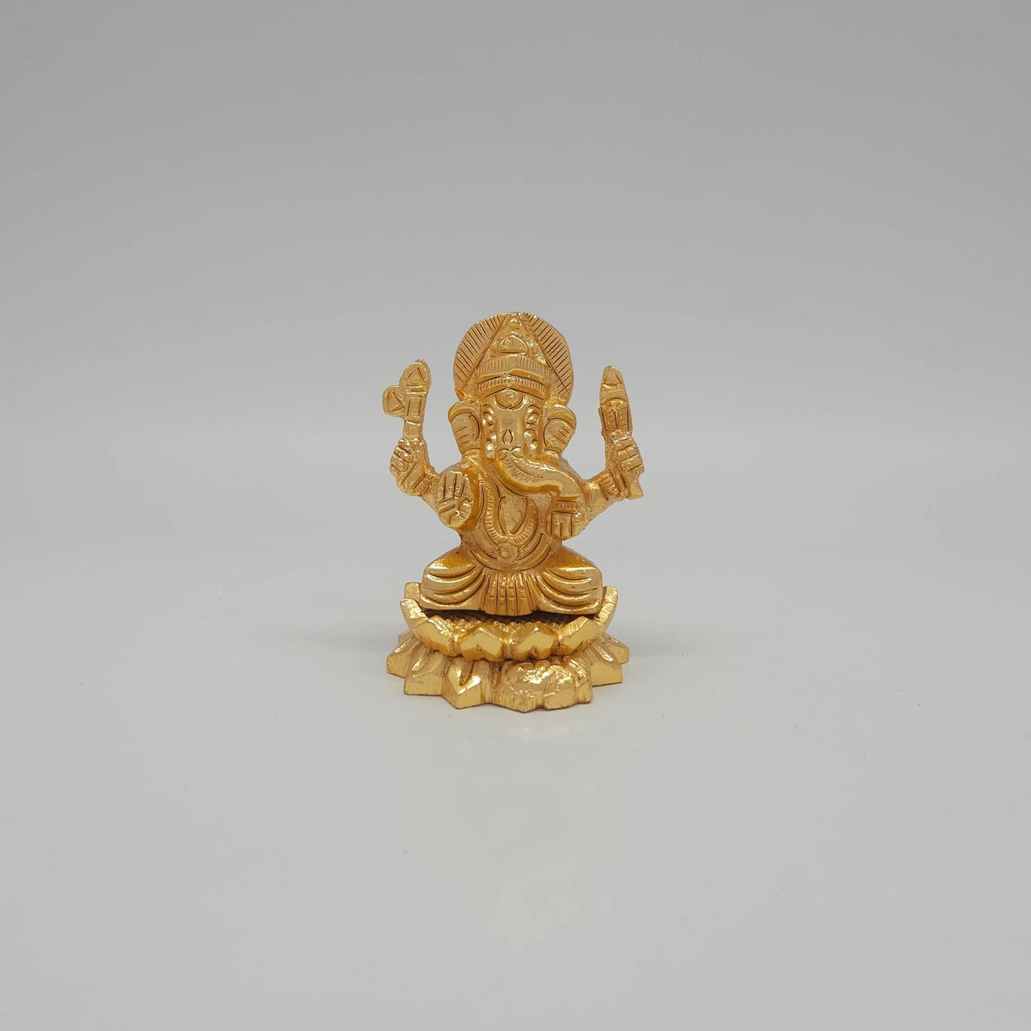 Front view of the 2-inch gold powder-coated brass Ganesha sitting lotus decorative figurine by Sri Swaminathan & Co