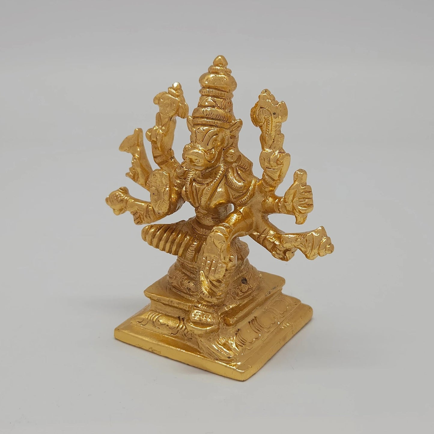 Left 45-degree angle profile emphasizing Varahi's face profile, the pestle weapon detail, and the ornate tiered base borders.